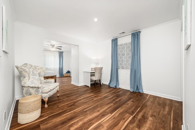 living area with crown molding, ceiling fan, and dark wood-type flooring