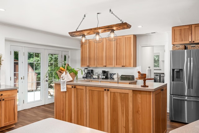 kitchen with french doors, stainless steel refrigerator with ice dispenser, washer and dryer, dark hardwood / wood-style floors, and decorative light fixtures