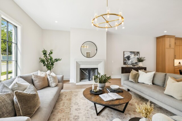 living room with light wood-type flooring and a notable chandelier