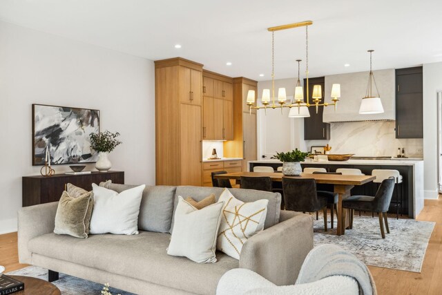 living room with an inviting chandelier and light hardwood / wood-style flooring