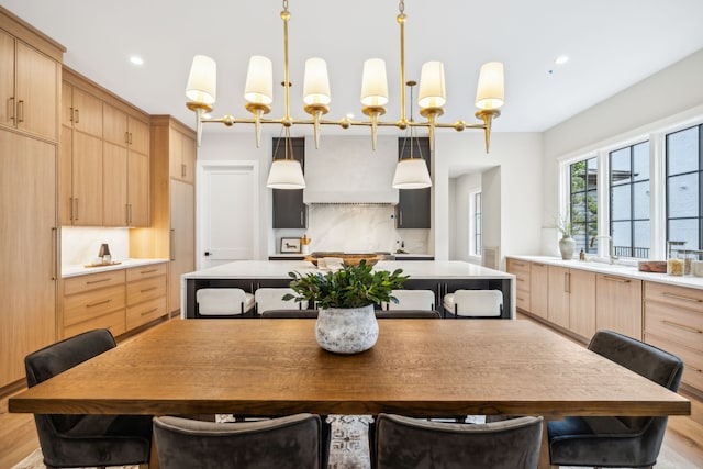 kitchen featuring light hardwood / wood-style floors, decorative backsplash, sink, light brown cabinets, and a center island