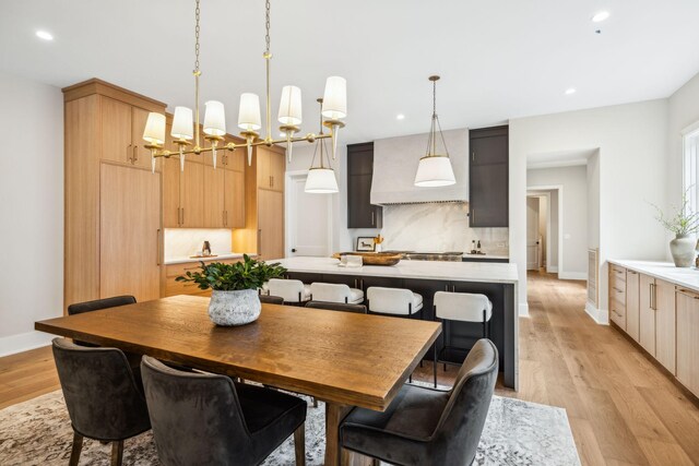 dining room with light hardwood / wood-style floors and a notable chandelier