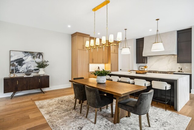 dining room with light hardwood / wood-style flooring and an inviting chandelier