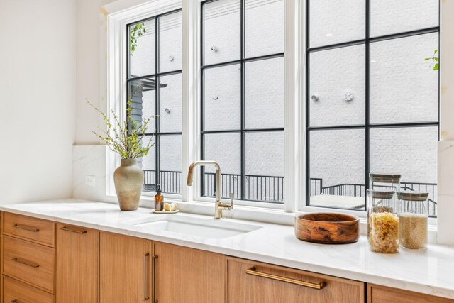 bar with sink and light stone countertops