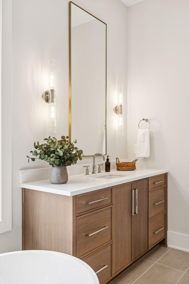 bathroom with a washtub, tile patterned floors, and vanity