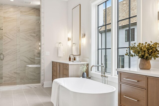 bathroom featuring tile patterned flooring, independent shower and bath, and vanity