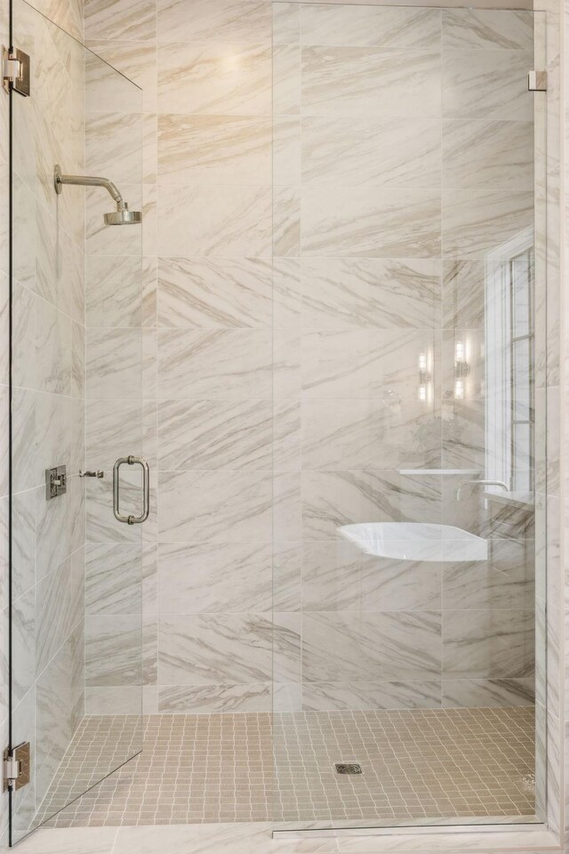 bathroom featuring a shower with shower door