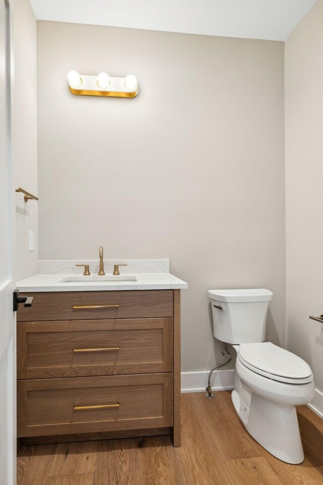 bathroom featuring toilet, hardwood / wood-style flooring, and vanity