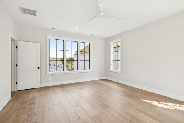 spare room with ceiling fan and light wood-type flooring