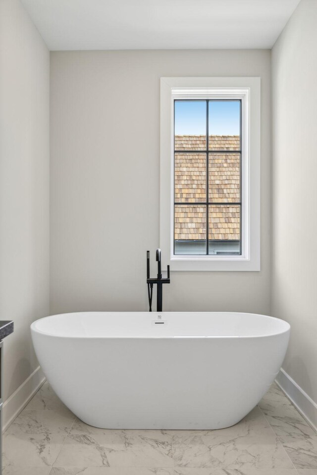 bathroom with a wealth of natural light, a bath, and tile patterned floors