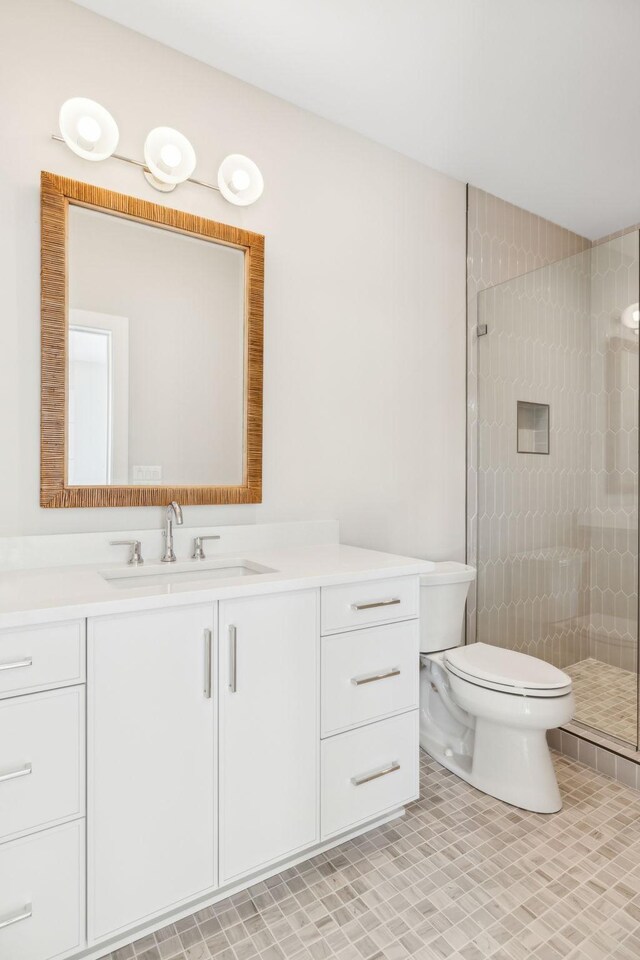 bathroom featuring tiled shower, tile patterned floors, toilet, and vanity