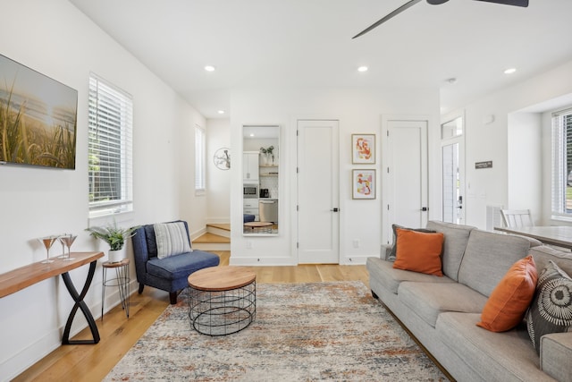 living room with ceiling fan and light hardwood / wood-style flooring