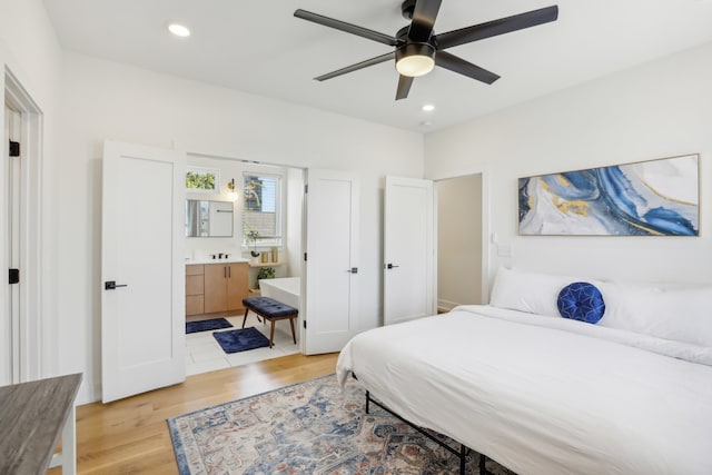 bedroom with ceiling fan, ensuite bath, and light hardwood / wood-style flooring