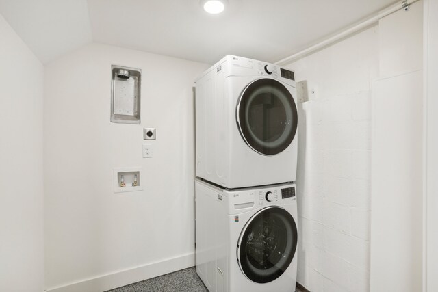 clothes washing area featuring stacked washer / dryer