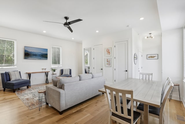 living room featuring ceiling fan, light wood-type flooring, and a wealth of natural light