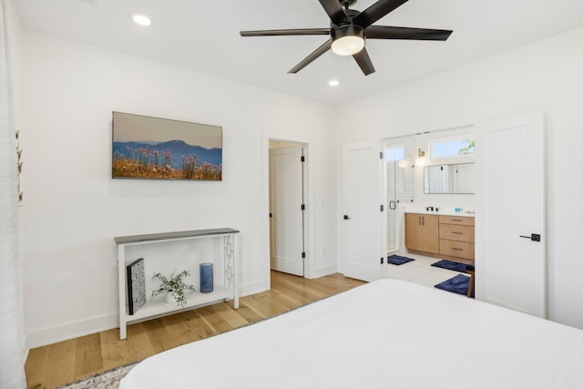 bedroom featuring ceiling fan, ensuite bath, and light hardwood / wood-style flooring