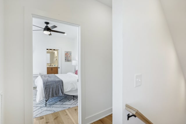 bedroom featuring ensuite bathroom and light wood-type flooring