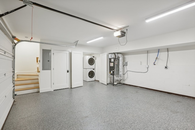 garage featuring a garage door opener, electric panel, and stacked washer and clothes dryer