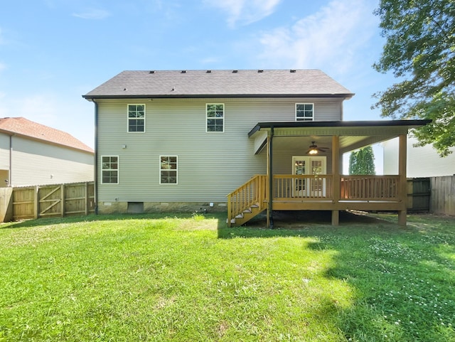 rear view of property with a lawn, a wooden deck, and ceiling fan