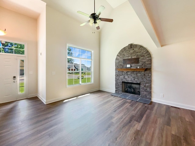 unfurnished living room with a fireplace, high vaulted ceiling, a healthy amount of sunlight, and dark hardwood / wood-style floors