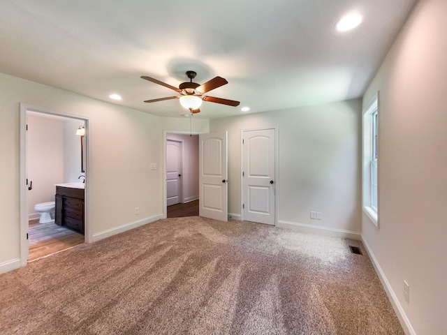 unfurnished bedroom with connected bathroom, carpet floors, and ceiling fan