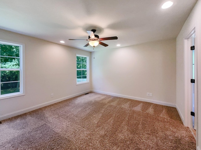 unfurnished room with ceiling fan and carpet