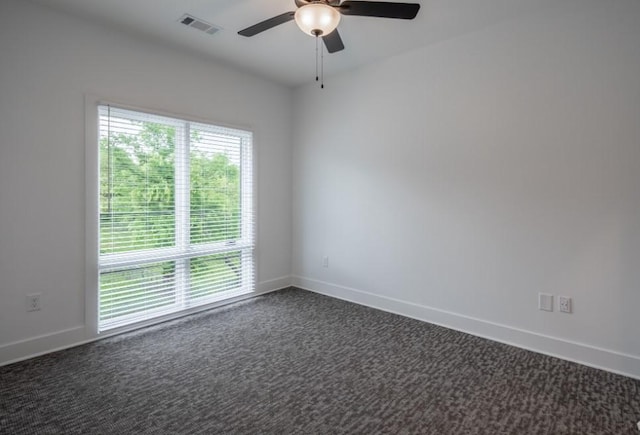 empty room with dark carpet and ceiling fan