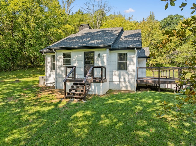 rear view of house featuring a deck and a yard