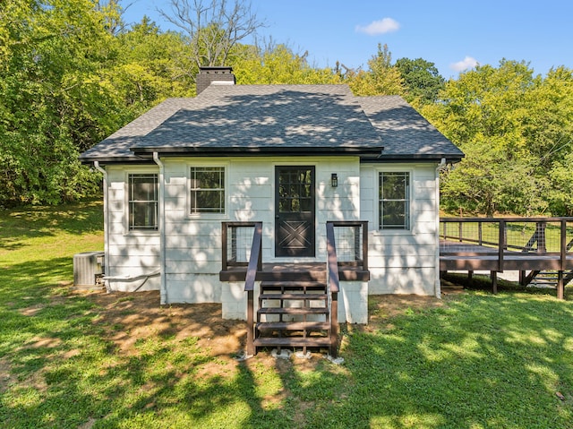 exterior space featuring a front lawn, cooling unit, and a deck