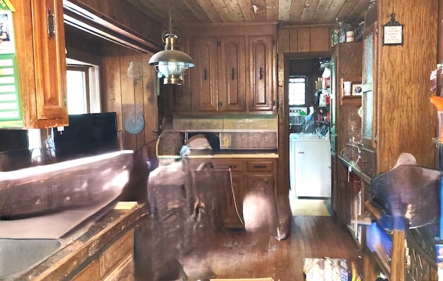 kitchen with washer / dryer, decorative light fixtures, wood walls, and wood ceiling