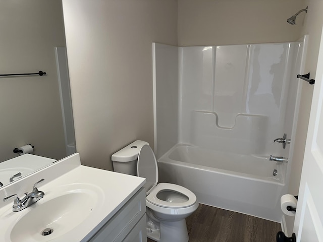 full bathroom with washtub / shower combination, wood-type flooring, vanity, and toilet