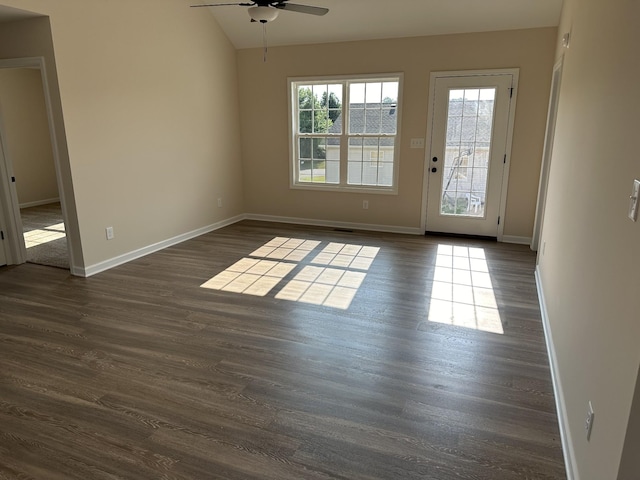 empty room featuring vaulted ceiling, ceiling fan, and dark wood-type flooring