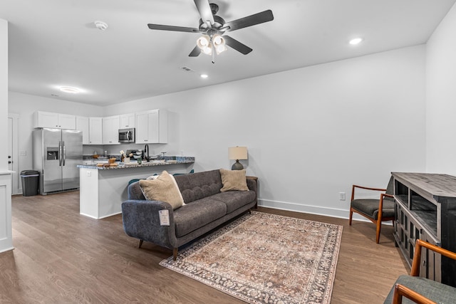 living room featuring recessed lighting, visible vents, a ceiling fan, wood finished floors, and baseboards