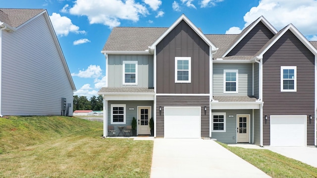 view of front facade featuring board and batten siding, a garage, driveway, and a front lawn