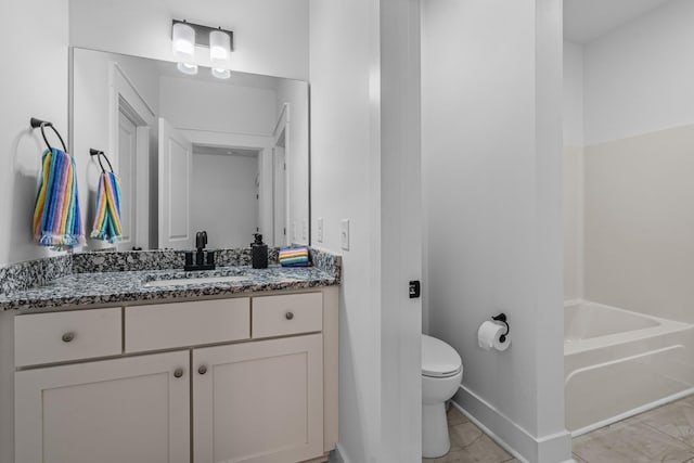 bathroom featuring a washtub, vanity, toilet, and baseboards