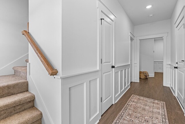 hall featuring dark wood-type flooring, recessed lighting, and stairs