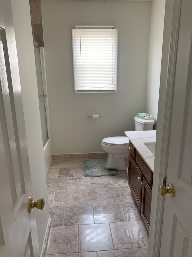 full bathroom featuring toilet, vanity, and bath / shower combo with glass door