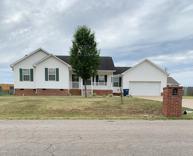 ranch-style home featuring a front yard, a garage, and a porch