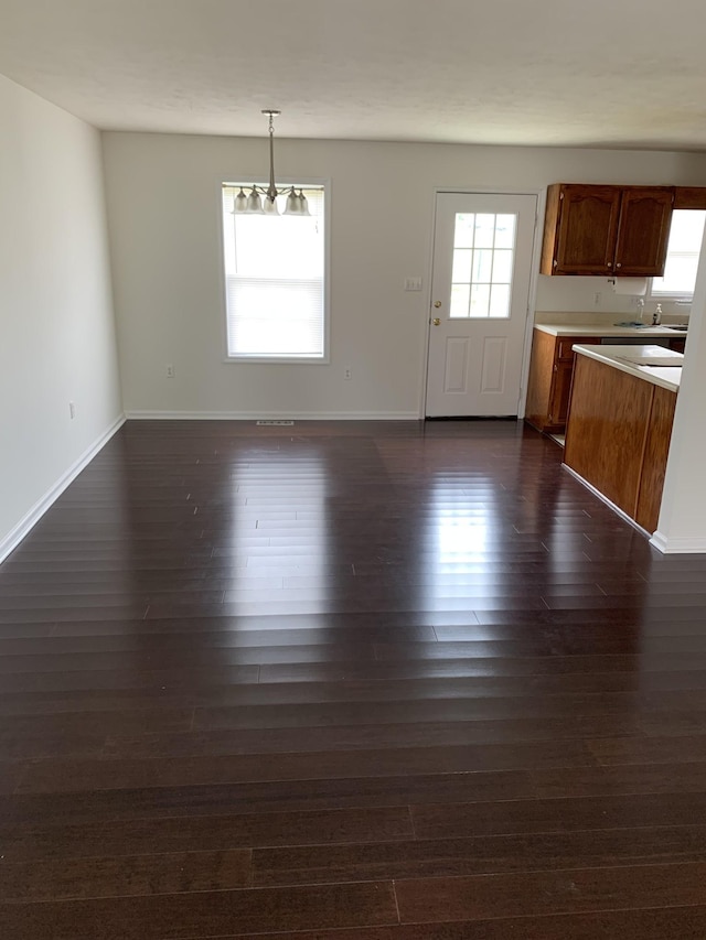 unfurnished dining area with a healthy amount of sunlight and dark hardwood / wood-style floors