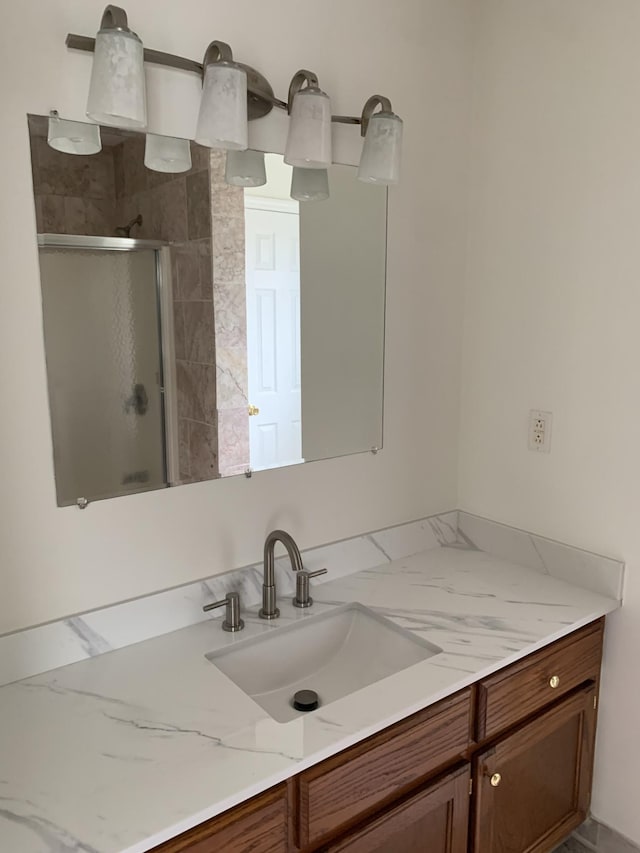 bathroom with walk in shower and vanity