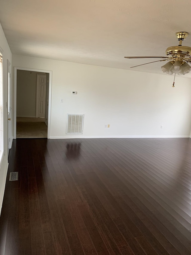 empty room with ceiling fan and dark hardwood / wood-style floors