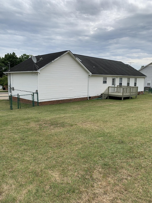 rear view of house with a wooden deck and a lawn