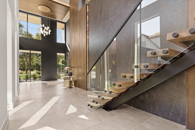 stairs with a high ceiling, tile patterned floors, and wooden ceiling