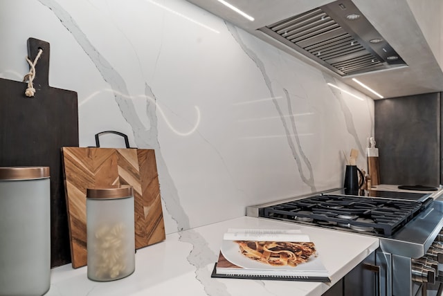 kitchen with stainless steel gas range oven and wall chimney exhaust hood