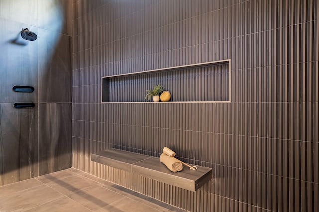 bathroom with a tile shower and tile patterned flooring