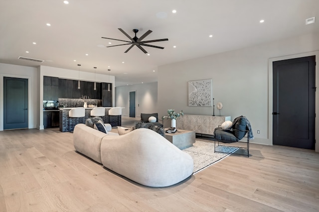 living room with ceiling fan and light hardwood / wood-style floors