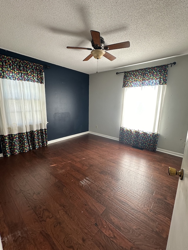 unfurnished room with a textured ceiling, dark hardwood / wood-style floors, and ceiling fan