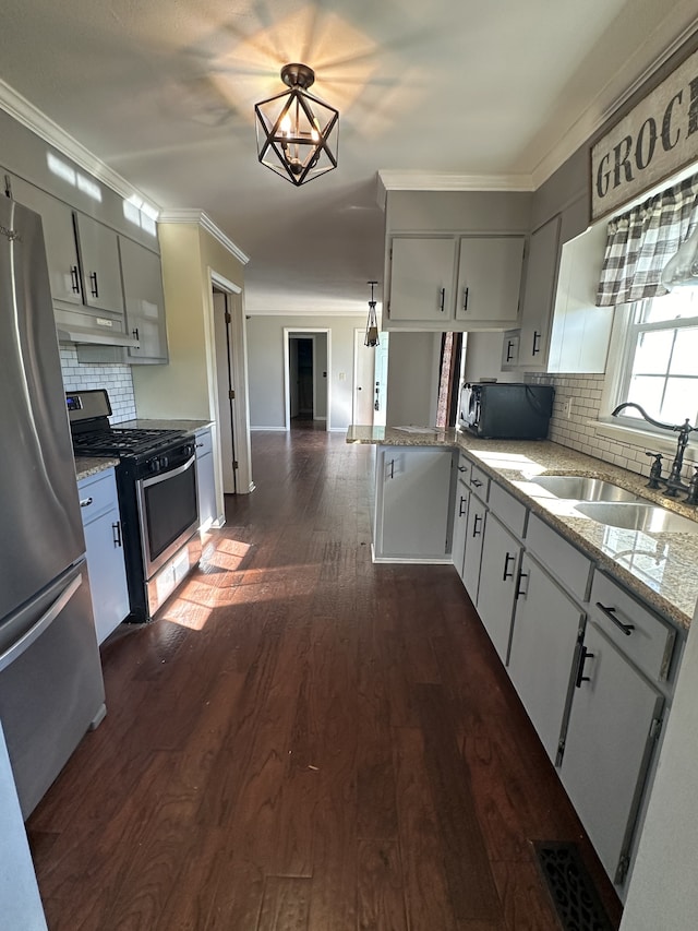 kitchen featuring sink, decorative backsplash, dark hardwood / wood-style floors, light stone counters, and stainless steel appliances