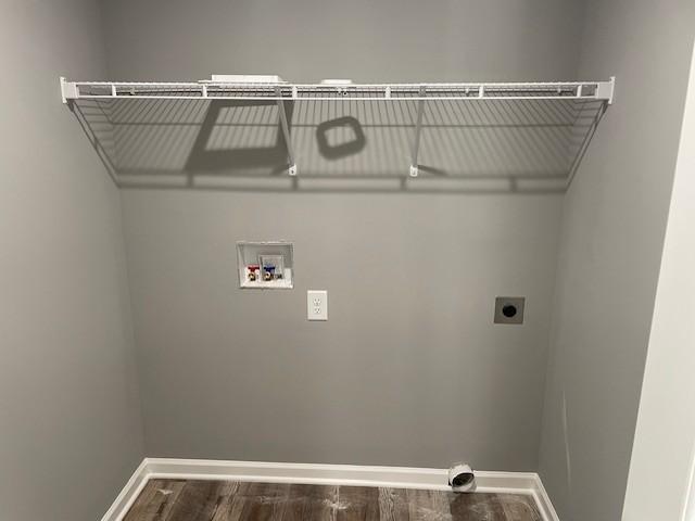 laundry room with hookup for an electric dryer, washer hookup, baseboards, wood finished floors, and laundry area