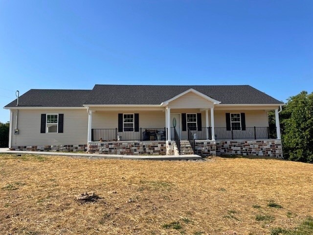 ranch-style house with a front yard and a porch